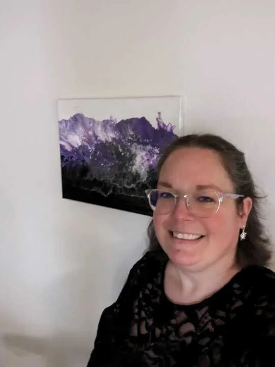 A purple landscape-inspired painting shown with its new owner.